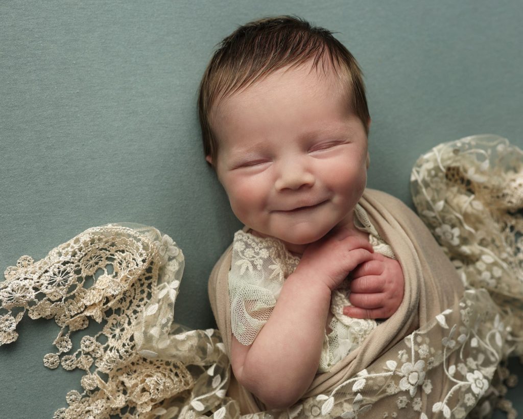 smiling newborn wrapped up.