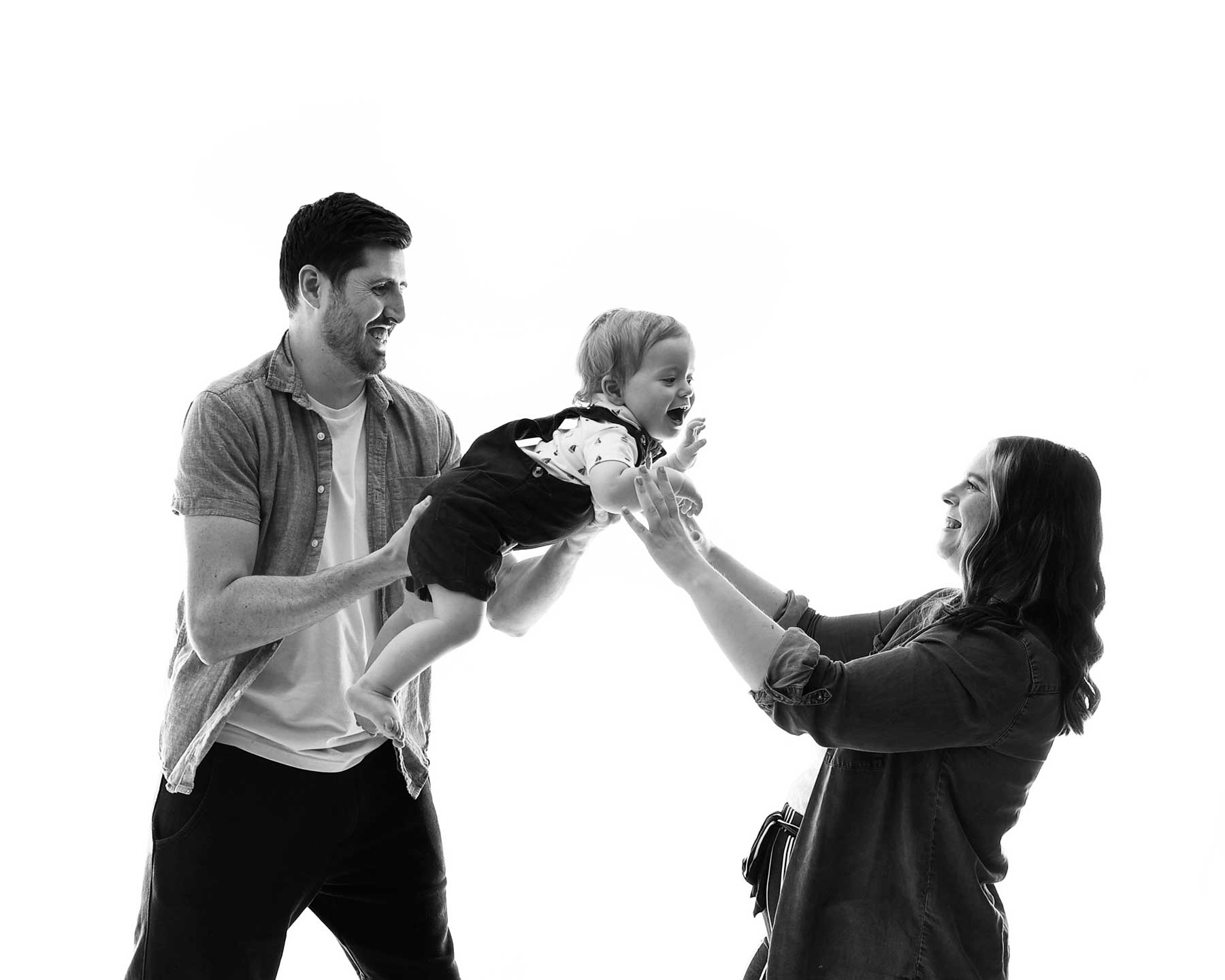 mum, dad and baby portrait on white background in black and white